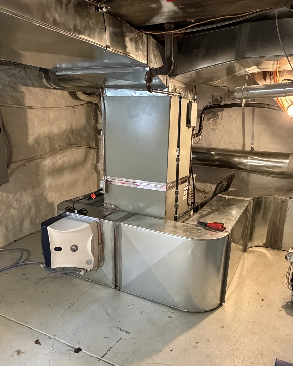 Indoor HVAC system with sheet-metal ductwork and a duct-mounted humidifier